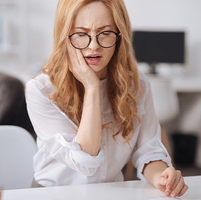 Woman in pain holding jaw