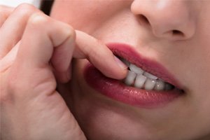 closeup of woman biting fingernails 