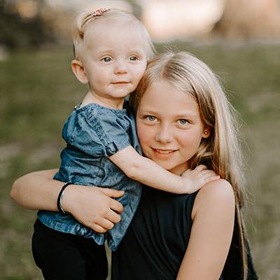 Young girl and toddler smiling together