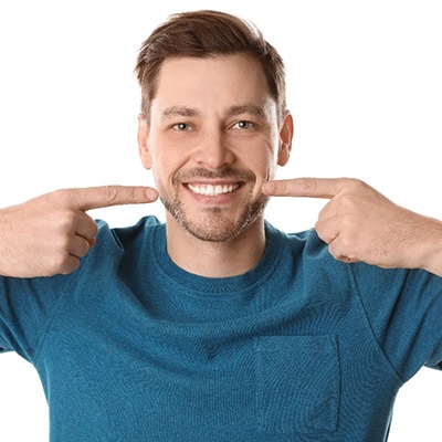 Smiling man points to his teeth