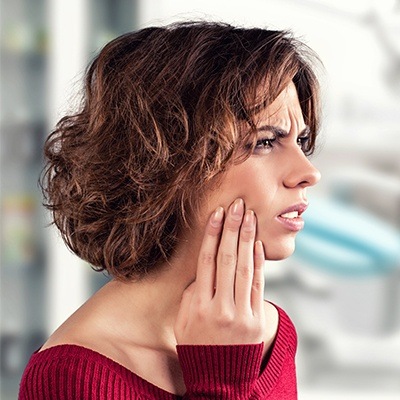 Woman in pain holding cheek