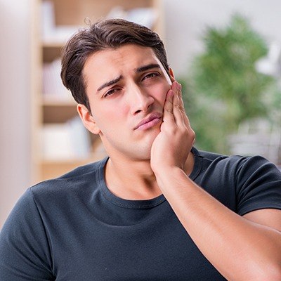 Man in pain holding jaw