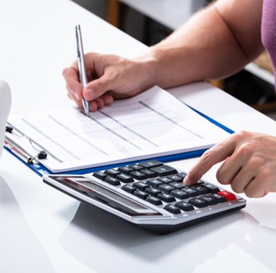 Person using calculator to budget for dental treatment