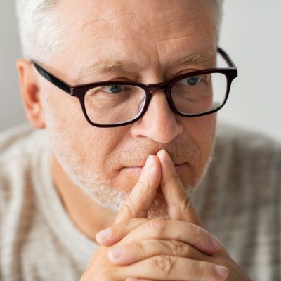 Older man covering his mouth