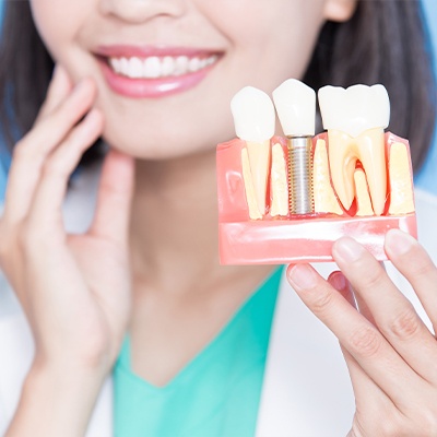 Dentist holding dental implant model