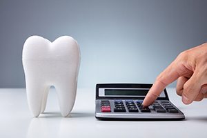 Tooth next to finger typing on a calculator