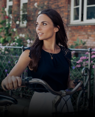 Woman holding bicycle outdoors