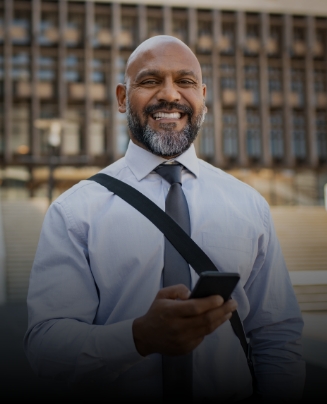 Man in dress shirt and tie smiling outdoors