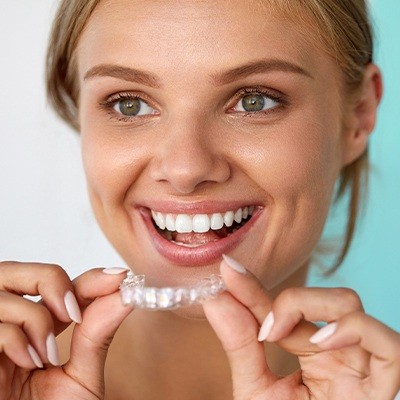 Woman placing Invisalign tray