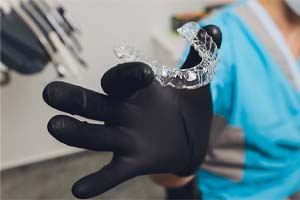 Dentist holding Invisalign aligner