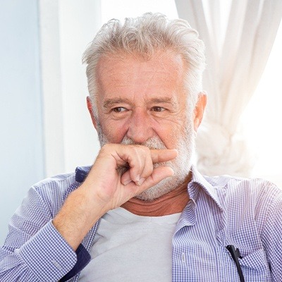 Older man covering his mouth