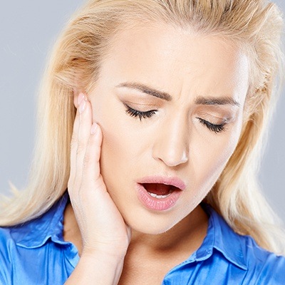 Woman in pain holding jaw