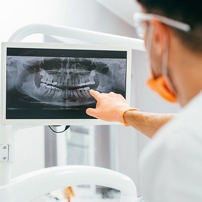 Dentist pointing to digital x-rays