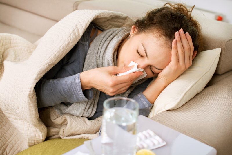 A sick woman lying on a couch.