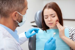 young woman in pain talking to her emergency dentist in Springfield 