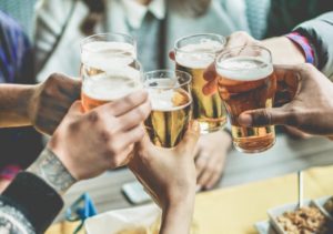 Close up of group of people toasting with glasses of beer