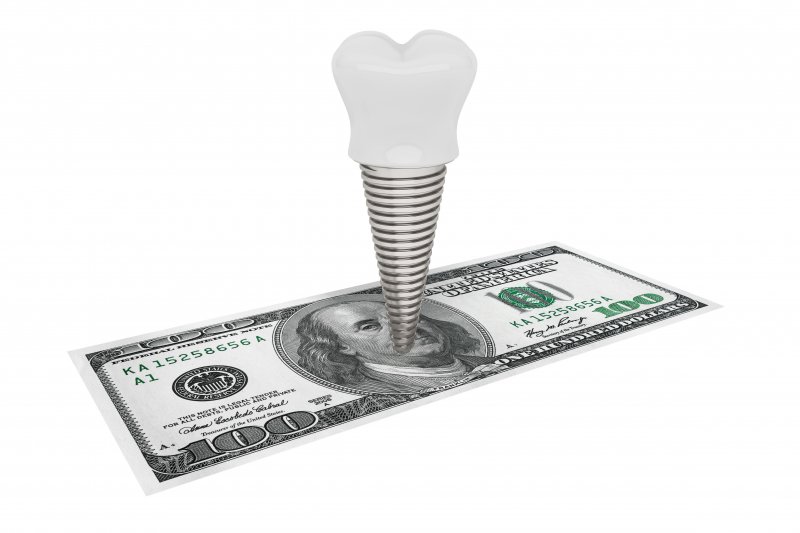 Dental implant standing on a hundred dollar bill