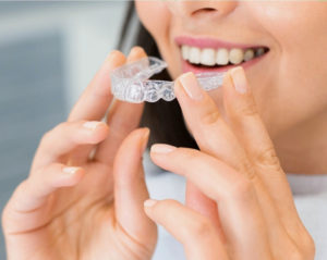 Woman inserting Invisalign