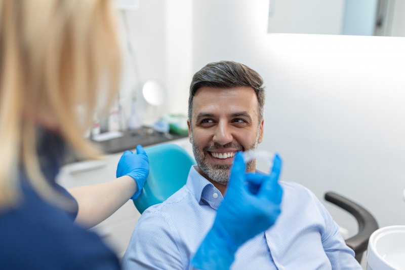 A man with dental bonding smiling after his teeth whitening treatment